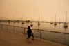 People walk on the waterfront in Toronto as wildfire smoke fills the city on Wednesday, July 15, 2026. THE CANADIAN PRESS/Laura Proctor