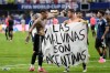 Argentina's Giovani Lo Celso holds a banner with the words 