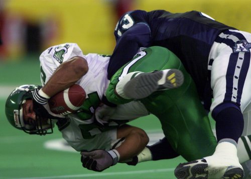 Saskatchewan Roughriders slotback Eric Guliford (84) is flipped up and hammered to the turf by Toronto Argonauts linebacker Calvin Tiggle during second-quarter CFL action in Toronto on Saturday, Aug. 25, 2001. (CP PHOTO/Frank Gunn)