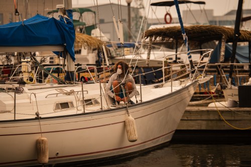 A man in a mask works on his sailboat in Toronto as wildfire smoke fills the city, on Wednesday, July 15, 2026. THE CANADIAN PRESS/Laura Proctor