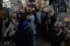 A woman flashes a victory sign while walking at Tehran's traditional main bazaar, Iran, Thursday, July 16, 2026. (AP Photo/Vahid Salemi)