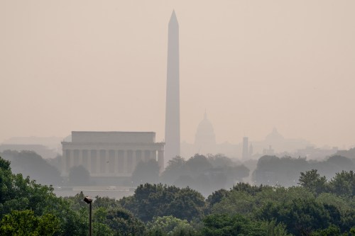 The Lincoln Memorial, the Washington Monument, and the U.S. Capitol, are barely visible from an overlook in Arlington, Va., as heavy smoke from wildfires shrouds the landscape in Washington, Friday, July 17, 2026. (AP Photo/J. Scott Applewhite)