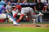 Colorado Rockies catcher Hunter Goodman, left, fields the throw as Cincinnati Reds' Spencer Steer slides safely into home plate to notch an inside-the-park home run off Colorado relief pitcher Jeff Criswell in the eighth inning of a baseball game Friday, July 17, 2026, in Denver. (AP Photo/David Zalubowski)