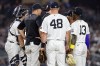 New York Yankees manager Aaron Boone, second left, confers with Gerrit Cole during the seventh inning of a baseball game against the Los Angeles Dodgers, Friday, July 17, 2026, in New York. (AP Photo/Adam Hunger)