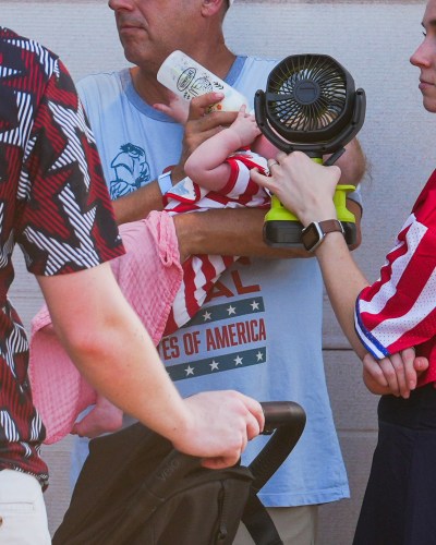 A woman holds a fan in front of a bottle-fed baby at the Great American State Fair, during an extreme heat wave, Friday, July 3, 2026, on the National Mall in Washington. (AP Photo/Julia Demaree Nikhinson)