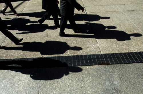 Businessmen cast their shadows as they walk in Toronto's financial district on Monday, Feb. 27, 2012. A new report says the gender pay gap in Canada last year narrowed compared with 2021, but still stood at more than 20 per cent. THE CANADIAN PRESS/Nathan Denette