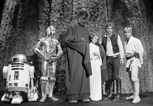 FILE - Kenny Baker, from left, Anthony Daniels, Peter Mayhew, Carrie Fisher, Harrison Ford and Mark Hamill are seen during the filming of the CBS-TV special, 