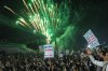 Fireworks burst as Houthi supporters rally against the Saudi-led coalition in Sanaa, Yemen, Monday, July 20, 2026. Placards in Arabic read: 