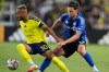 Nashville SC midfielder Hany Mukhtar (10) moves the ball past CF Montréal defender Luca Petrasso (13) during the first half of an MLS soccer match Wednesday, July 22, 2026, in Nashville, Tenn. (AP Photo/George Walker IV)
