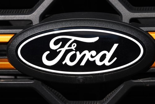 FILE - A Ford logo is seen on the grille of an unsold vehicle at a Ford dealership, Nov. 2, 2025, in Littleton, Colo. (AP Photo/David Zalubowski, File)