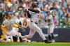 Colorado Rockies designated hitter Mickey Moniak hits a sacrifice fly, allowing Willi Castro to score, as Milwaukee Brewers catcher William Contreras, left, looks on during the fourth inning of a baseball game Friday, July 24, 2026, in Milwaukee. (AP Photo/Kayla Wolf)