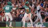 Toronto Blue Jays pitcher CJ Van Eyk, right, heads back to the mound as Boston Red Sox's Jarren Duran, centre, is congratulated by Anthony Seigler (48) after scoring on a double, during the eighth inning of a baseball game, Friday, July 24, 2026, in Boston. (AP Photo/Charles Krupa)