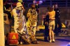 Two people embrace near others wearing thermal blankets as they stand near emergency personnel in Berlin, early Sunday, July 26, 2026, following the cancellation of Christopher Street Day festivities. (AP Photo/Markus Schreiber)