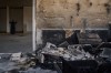 A Palestinian man prays inside a mosque that was burned during an attack by Israeli settlers early in the morning in the West Bank village of Qusra, Sunday, July 26, 2026. (AP Photo/Leo Correa)