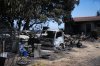 Burnt vehicles sit outside a charred house in Navas del Rey, west of Madrid, Spain, where wildfires have forced tens of thousands to be evacuated, Sunday, July 26, 2026. (AP Photo/Manu Fernandez)