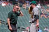 Athletics trainer Jeff Collins, left, visits starting pitcher Jeffrey Springs, right, in the second inning of a baseball game against the Minnesota Twins, Sunday, July 26, 2026, in Minneapolis. (AP Photo/Bruce Kluckhohn)