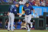 Seattle Mariners designated hitter Dominic Canzone (8) is congratulated by third base coach Carlos Cardoza, left, after hitting a home run during the seventh inning of a baseball game against the Texas Rangers, Sunday, July 26, 2026, in Arlington, Texas. (AP Photo/LM Otero)