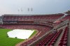 The infield is covered during a rain delay before a baseball game between the Cleveland Guardians and the Cincinnati Reds, Monday, July 27, 2026, in Cincinnati. (AP Photo/Kareem Elgazzar)