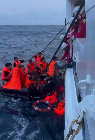 In this photo released by Xinhua News Agency, crew members on Nanhai Jiu 115, a rescue vessel operated by the Nanhai Rescue Bureau of China's Ministry of Transport, pick up crew members of Vietnamese vessel Khoi Nguyen from a life raft in the South China Sea on July 25, 2026. (Sansha Maritime Safety Administration//Xinhua via AP)
