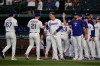 Texas Rangers' Jacob Latz (67), Jake Burger (21), Joc Pederson, center, Nathan Eovaldi, right and the rest of the team celebrate their win against the Seattle Mariners in a baseball game in Arlington, Texas, Monday, July 27, 2026. (AP Photo/Tony Gutierrez)