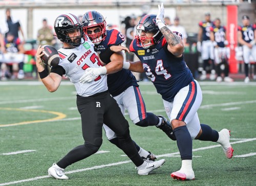 Ottawa Redblacks quarterback Jake Maier (13) is sacked by Alouettes defenders Isaac Adeyemi-Berglund (91) and Mustafa Johnson (94) in Montreal on Sunday, June 28, 2026. THE CANADIAN PRESS/Graham Hughes