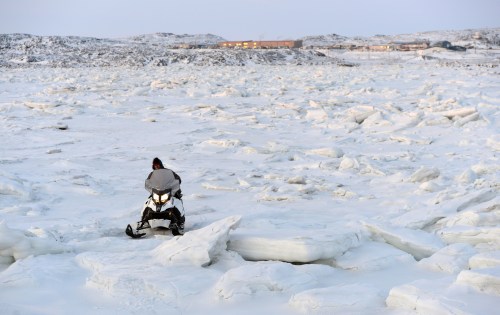 A snowmobiler makes his way through the ice heaves in Frobisher Bay in Iqaluit, Nunavut on Dec. 10, 2014. THE CANADIAN PRESS/Sean Kilpatrick