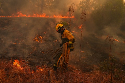 FILE - A firefighter carries a hose while battling a wildfire in San Martin de Valdeiglesias, west of Madrid, Spain, July 26, 2026. (AP Photo/Manu Fernandez, File)
