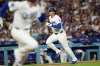 Los Angeles Dodgers' Shohei Ohtani (17) scores on an infield hit by Freddie Freeman (5) against the Seattle Mariners during the third inning of a baseball game Wednesday, July 29, 2026, in Los Angeles. (AP Photo/Scott Strazzante)