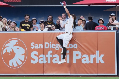 San Diego Padres right fielder Fernando Tatis Jr. makes the catch above the wall for the out on a sacrifice fly by San Francisco Giants' Rafael Devers during the first inning of a baseball game Thursday, July 30, 2026, in San Diego. (AP Photo/Gregory Bull)
