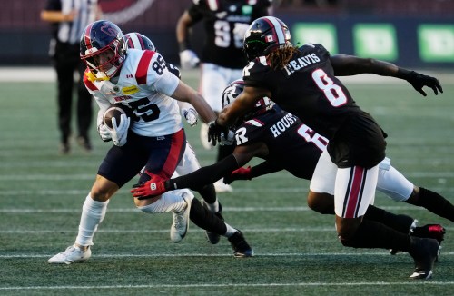 Montreal Alouettes' Tyler Snead (85) tries to get past Ottawa Redblacks' CJ Reavis (8) and Demerio Houston (6) during first half CFL action in Ottawa, Friday, July 31, 2026. THE CANADIAN PRESS/Adrian Wyld