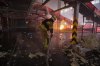 Firefighter put out a fire at a Nova Poshta postal warehouse following Russian air attack on the outskirts of Kharkiv, Ukraine, Sunday, Aug. 2, 2026. (AP Photo/Yevhen Titov)