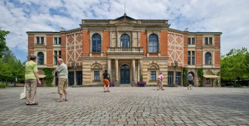 FILE - Visitors walk the grounds of the festival opera house 
