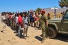 Migrants who crossed into Spain from Morocco line up for water distributed by Spanish soldiers in the Spanish enclave of Ceuta, Sunday, Aug. 2, 2026. (AP Photo/Bernat Armangue)