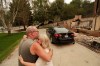 Allen Sather and his wife Kimberley embrace at the duplex they rent on W. Indian Trail Rd. after it burned in a wildfire in Spokane, Wash., Sunday, Aug. 2, 2026. (AP Photo/Young Kwak)