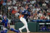 Houston Astros' Yordan Alvarez, right, hits a two-run double as Texas Rangers catcher Austin Wynns watches during the seventh inning of a baseball game Sunday, Aug. 2, 2026, in Houston. (AP Photo/David J. Phillip)