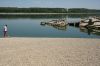 A man walks on the sandbank by the wreckage of a WWII German warship, emerged due to the drought, in front of Djerdap II, a large dam on the Danube River, between Romania and Serbia, near Prahovo, Serbia, Tuesday, Aug. 4, 2026. (AP Photo/Darko Vojinovic)