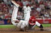 Cincinnati Reds' Sal Stewart dives across home plate to score the go-ahead run on a wild pitch by Athletics pitcher Hogan Harris during the eight inning of a baseball game in Cincinnati, Tuesday, Aug. 4, 2026. (AP Photo/Carolyn Kaster)