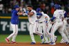 Texas Rangers' Alejandro Osuna, left, Ezequiel Duran, second from left, and the rest of the team celebrate Duran's run-scoring single in the ninth inning a baseball game against the San Francisco Giants in Arlington, Texas, Tuesday, Aug. 4, 2026. (AP Photo/Tony Gutierrez)