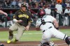 San Diego Padres' Manny Machado, left, scores a run as Arizona Diamondbacks catcher James McCann, right, loses the baseball during the first inning of a baseball game, Tuesday, Aug. 4, 2026, in Phoenix. (AP Photo/Ross D. Franklin)