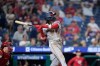 Washington Nationals' CJ Abrams follows through hitting a two-run triple against Philadelphia Phillies' Caleb Kilian during the 11th inning of a baseball game Wednesday, Aug. 5, 2026, in Philadelphia. (AP Photo/Matt Slocum)