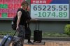 People walk past an electronic board showing Japan's Nikkei index at a securities firm Thursday, Aug. 6, 2026, in Tokyo. (AP Photo/Eugene Hoshiko)