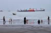 People spend time at a beach as commercial vessels are anchored in the Strait of Hormuz off Bandar Abbas, Iran, Wednesday, Aug. 5, 2026. (Amirhosein Khorgooi/ISNA via AP)