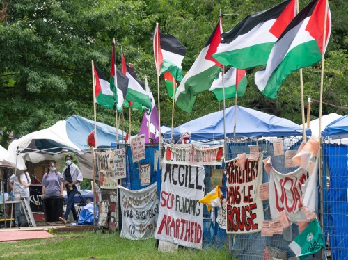 Supporters stand in front of the pro-Palestinian protest encampment on McGill University campus, in Montreal, Monday, June 17, 2024. THE CANADIAN PRESS/Ryan Remiorz