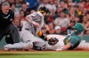 Boston Red Sox's Jake Rogers, right, beats a tag by Athletics' Jonah Heim, center, to score on a single hit by Ceddanne Rafaela during the seventh inning of a baseball game, Friday, Aug. 7, 2026, in Boston. (AP Photo/Charles Krupa)
