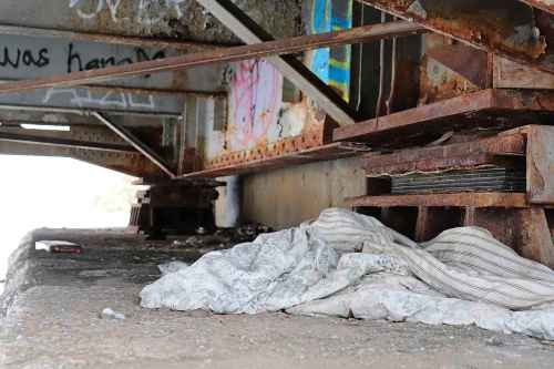 TYLER SEARLE / WINNIPEG FREE PRESS FILES

A blanket lay among broken glass and drug-use supplies beneath a bridge in the Point Douglas neighbourhood.