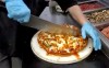 A pizza being cut at Tumblers Pizza in Regina. Tourism Regina has launched a campaign with new merchandise to showcase a pizza style made famous by Saskatchewan's capital. THE CANADIAN PRESS/Jeremy Simes