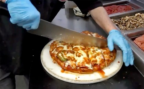 A pizza being cut at Tumblers Pizza in Regina. Tourism Regina has launched a campaign with new merchandise to showcase a pizza style made famous by Saskatchewan's capital. THE CANADIAN PRESS/Jeremy Simes
