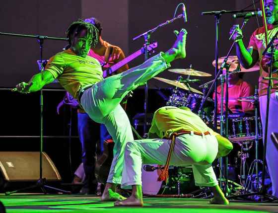 One performer (right) kicks while another ducks during a high-energy show at the Brazilian pavilion at the convention centre on Sunday. (John Woods / Free Press)