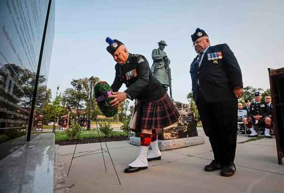 Lt.-Col. Mark Singleton (left) lays a wreath with chief warrant officer (retired) Stephen MacMillan as the Queen’s Own Cameron Highlanders hold a sunset ceremony at Vimy Ridge park Tuesday. (John Woods / Free Press)