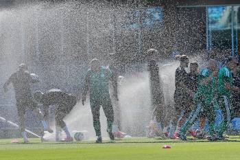 Eugene Hoshiko / THE ASSOCIATED PRESS FILES
                                Algeria players are sprayed by sprinklers during a training session ahead of Group J action at this summer&rsquo;s men&rsquo;s World Cup.